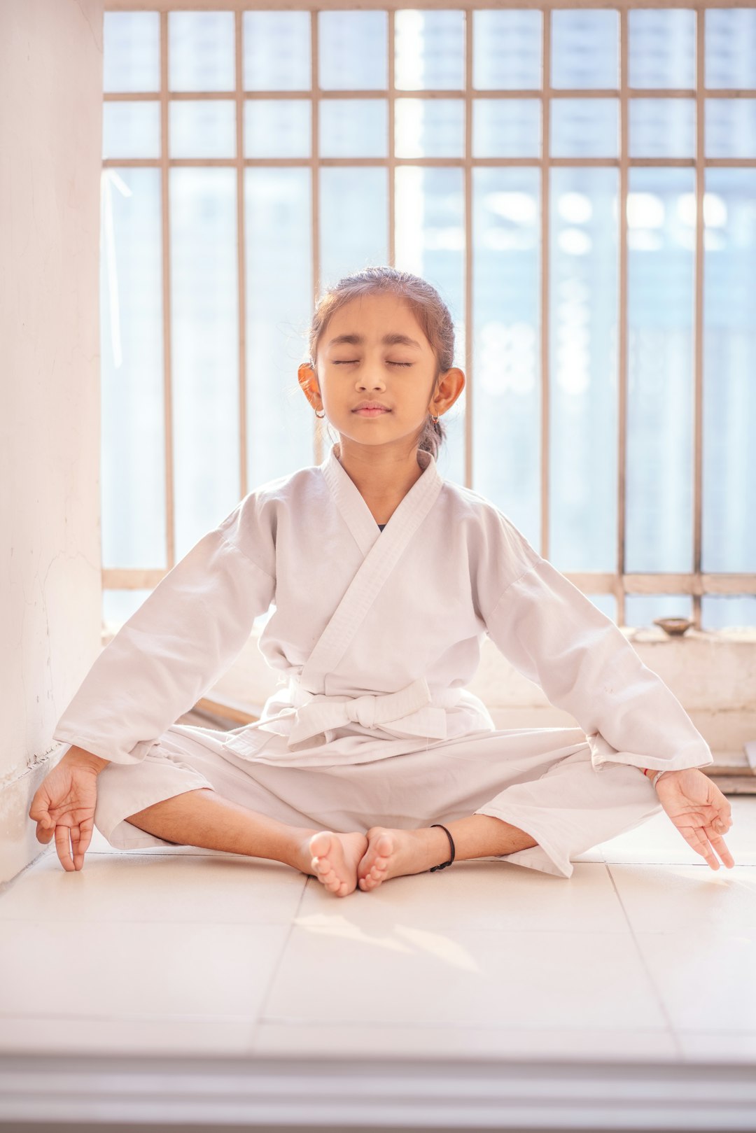 A little warrior in white GI, channeling fierce focus and boundless joy on the balcony stage, where every punch promises strength, every smile radiates pure confidence. With sunlight kissing her determined face and the world as her dojo, this tiny karate kid kicks open doors to discipline, dreams, and unstoppable spirit.